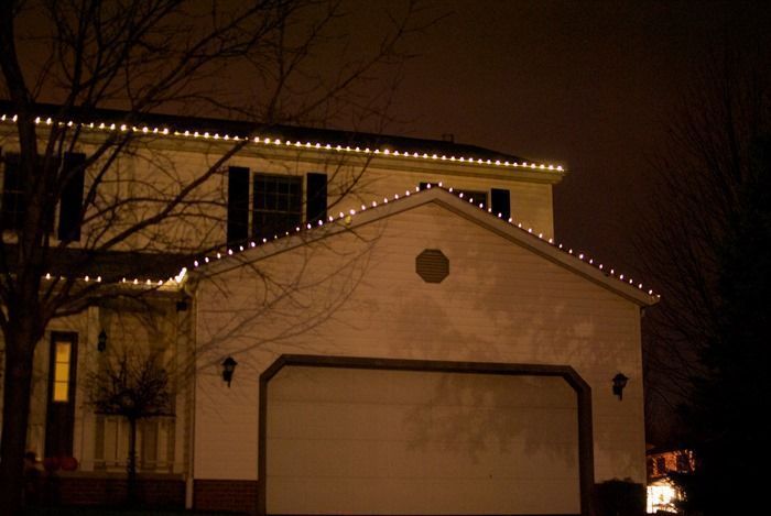 a white house with the roof edges lined with white christmas lights